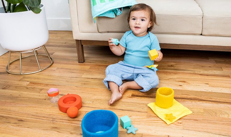 Toddler sorting different balls and containers by color