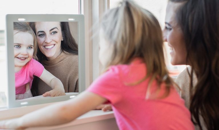 Toddler and woman looking at each other in a mirror